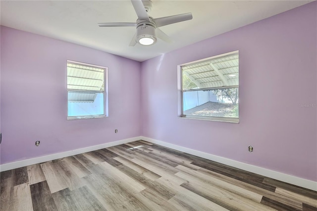 empty room featuring a ceiling fan, baseboards, and wood finished floors