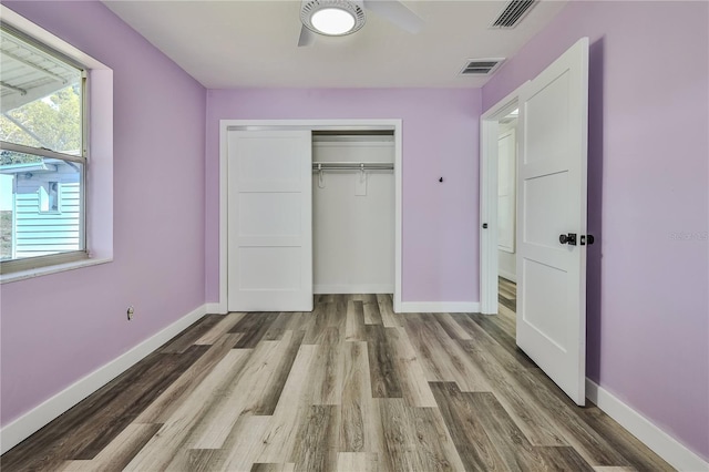 unfurnished bedroom featuring baseboards, visible vents, and wood finished floors