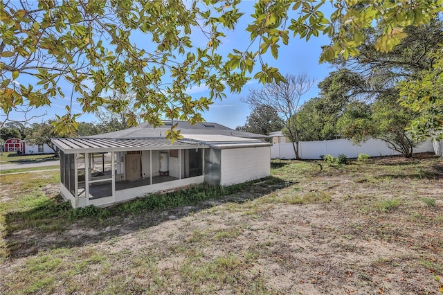 back of property with a sunroom and fence