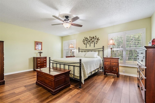 bedroom featuring baseboards, ceiling fan, a textured ceiling, and hardwood / wood-style floors