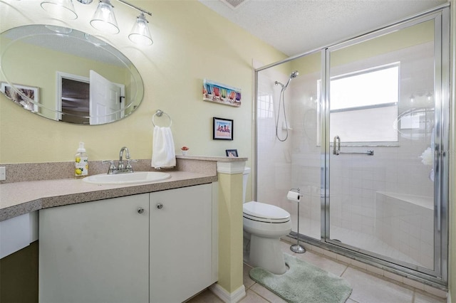 bathroom with a stall shower, a textured ceiling, toilet, and vanity