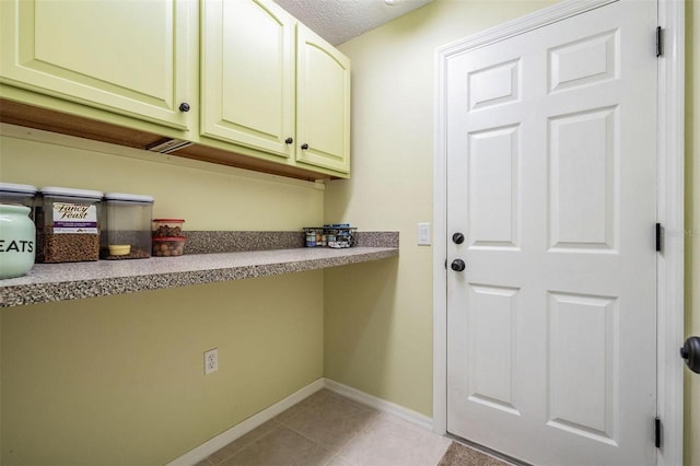 washroom with light tile patterned floors, a textured ceiling, and baseboards