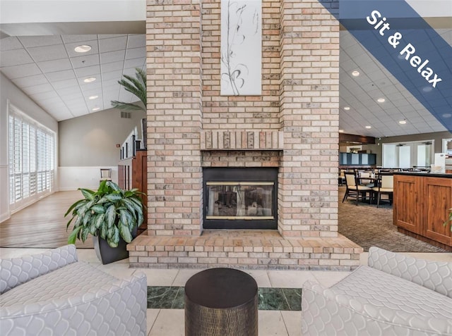 living area featuring a paneled ceiling, a brick fireplace, and recessed lighting