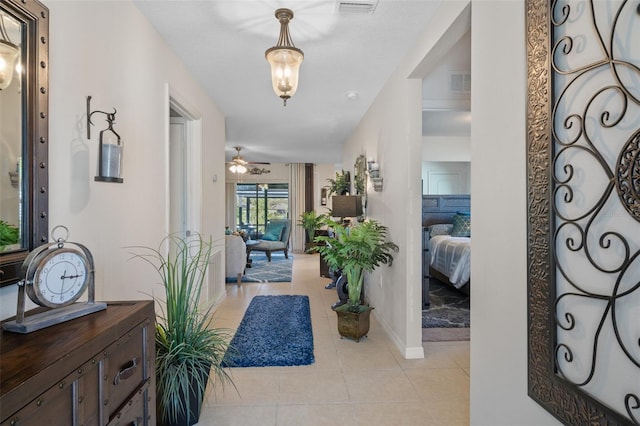 entrance foyer with ceiling fan, visible vents, baseboards, and light tile patterned flooring