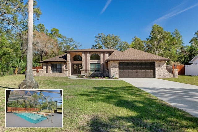 view of front facade featuring a front yard, brick siding, fence, and an attached garage