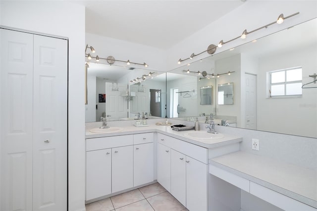 bathroom featuring tile patterned flooring, a closet, and a sink