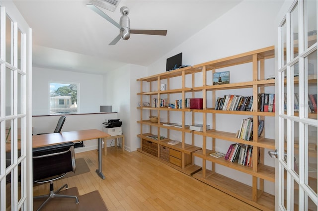 home office featuring visible vents, a ceiling fan, hardwood / wood-style floors, vaulted ceiling, and french doors