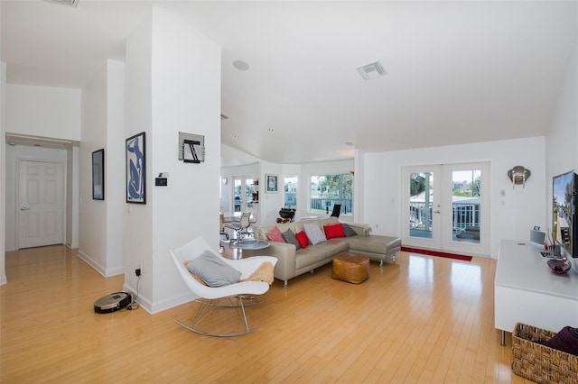 living area featuring french doors, visible vents, baseboards, and light wood finished floors