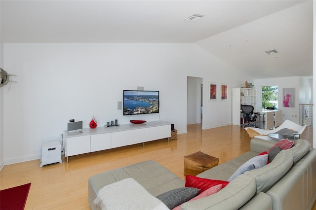 living room with light wood-style floors, visible vents, vaulted ceiling, and baseboards