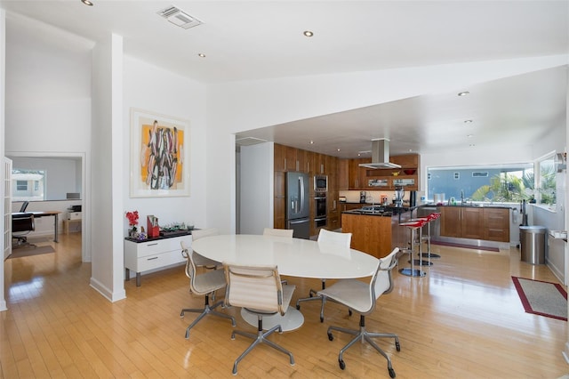 dining space featuring lofted ceiling, light wood-style flooring, visible vents, and recessed lighting