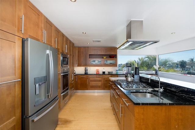 kitchen featuring a sink, stainless steel appliances, brown cabinetry, and island exhaust hood