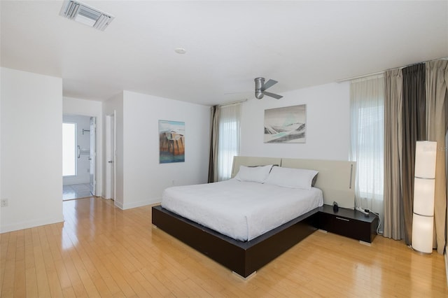 bedroom featuring light wood-style floors, visible vents, and multiple windows