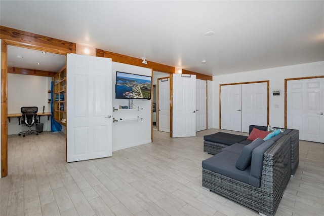 living room featuring light wood-type flooring and beam ceiling