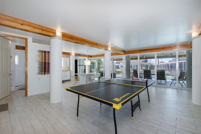 recreation room with beamed ceiling and wood tiled floor