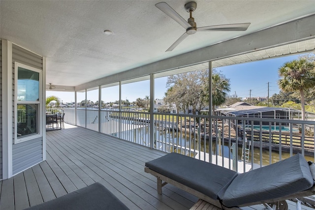 deck with a water view and a ceiling fan