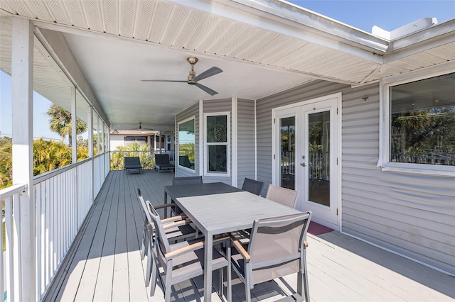 wooden deck with outdoor dining area, a ceiling fan, and french doors