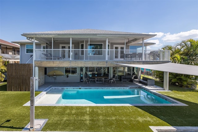 rear view of house featuring an outdoor pool, a balcony, a yard, a patio area, and an outdoor living space