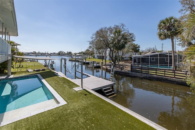 view of dock with an outdoor pool, glass enclosure, a yard, and a water view