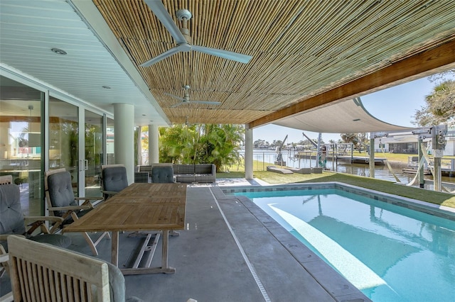 outdoor pool with a water view, a patio, and a boat dock