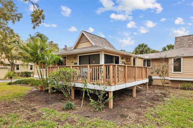 back of property with roof with shingles and a wooden deck