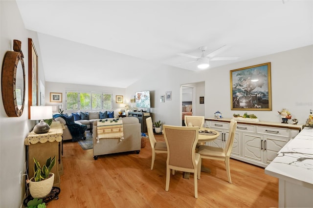 dining area featuring light wood finished floors, ceiling fan, and vaulted ceiling