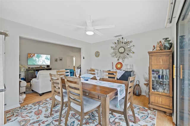 dining space with visible vents, ceiling fan, and light wood-style flooring