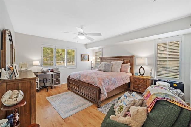 bedroom featuring ceiling fan, light wood-style flooring, and baseboards