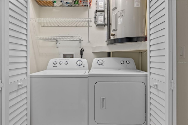 clothes washing area featuring laundry area, water heater, and separate washer and dryer