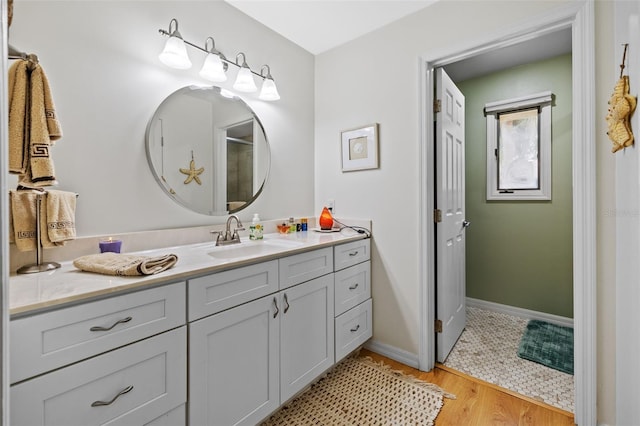 bathroom featuring baseboards, wood finished floors, and vanity