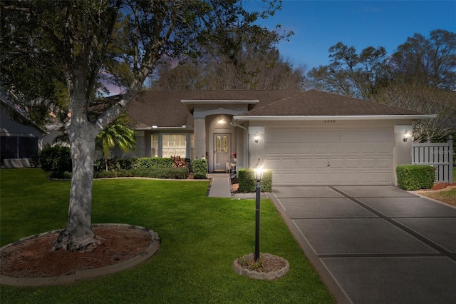 single story home featuring fence, an attached garage, stucco siding, a front lawn, and concrete driveway