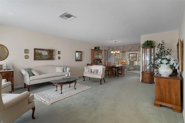 living area with baseboards, visible vents, a textured ceiling, a notable chandelier, and light colored carpet