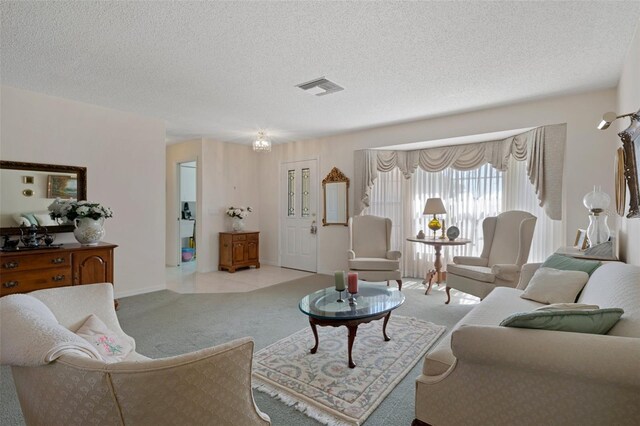 living room featuring a textured ceiling, baseboards, visible vents, and light carpet