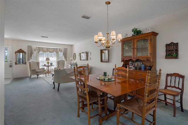 carpeted dining area with an inviting chandelier, visible vents, and a textured ceiling