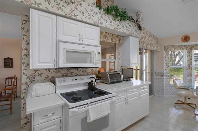 kitchen featuring wallpapered walls, a toaster, light countertops, vaulted ceiling, and white appliances