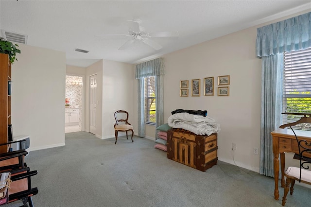 sitting room with a wealth of natural light, visible vents, baseboards, and carpet