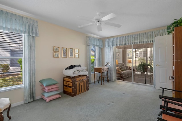 misc room with carpet flooring, a ceiling fan, baseboards, and a wealth of natural light