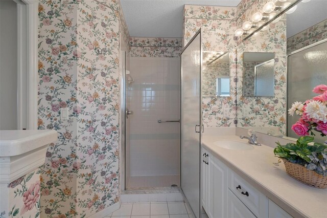 bathroom featuring wallpapered walls, a shower stall, and a textured ceiling