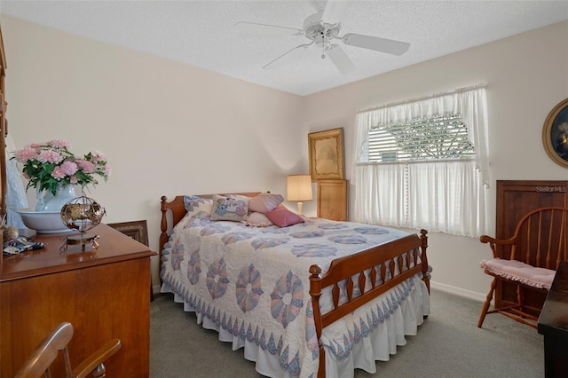 carpeted bedroom with a textured ceiling, baseboards, and a ceiling fan