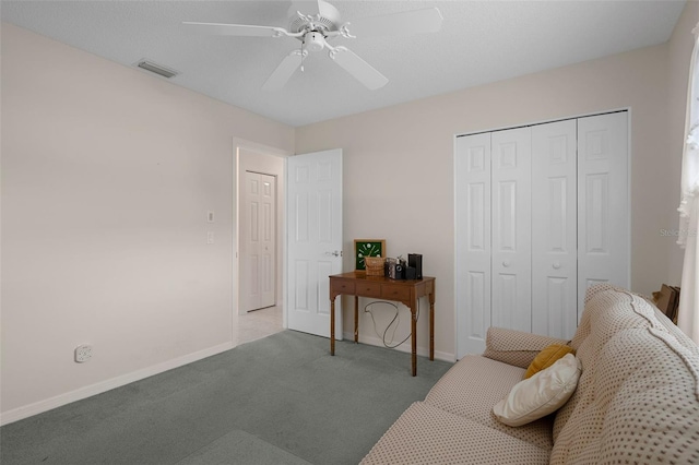 living area with visible vents, baseboards, a ceiling fan, and carpet flooring