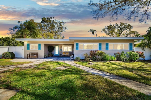 ranch-style house with a front yard and fence