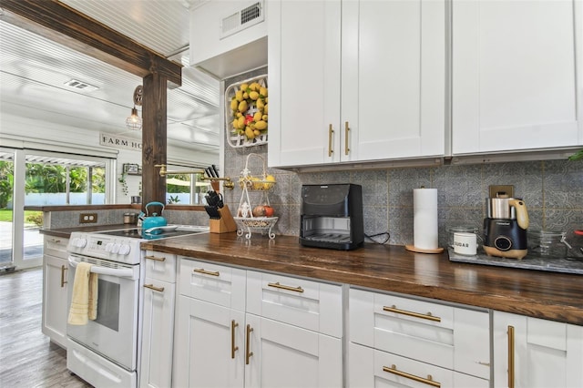 kitchen with white electric stove, wood counters, visible vents, white cabinets, and decorative backsplash