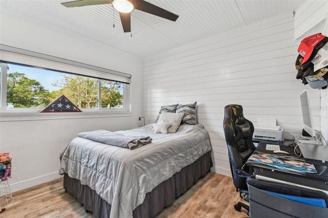 bedroom featuring a ceiling fan, light wood-style flooring, and baseboards