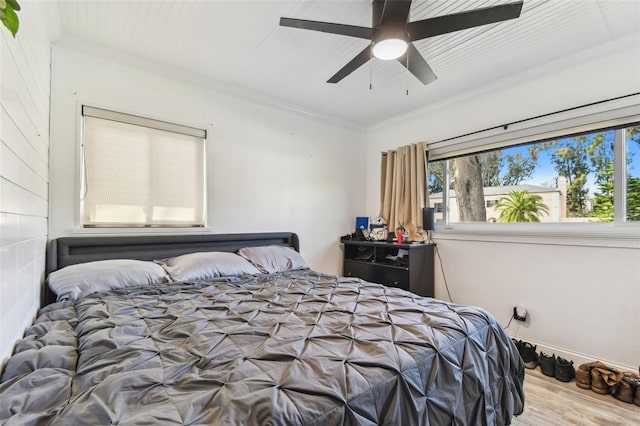 bedroom featuring wood finished floors, a ceiling fan, and crown molding