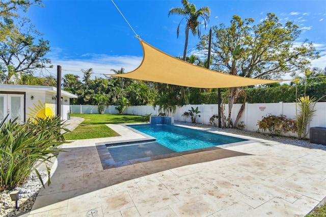 view of swimming pool featuring a patio, a fenced backyard, french doors, a lawn, and a fenced in pool