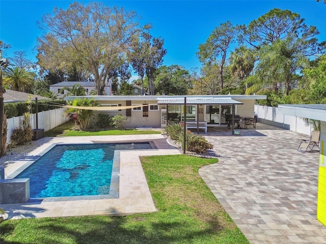 rear view of property featuring a patio, a fenced backyard, and a fenced in pool