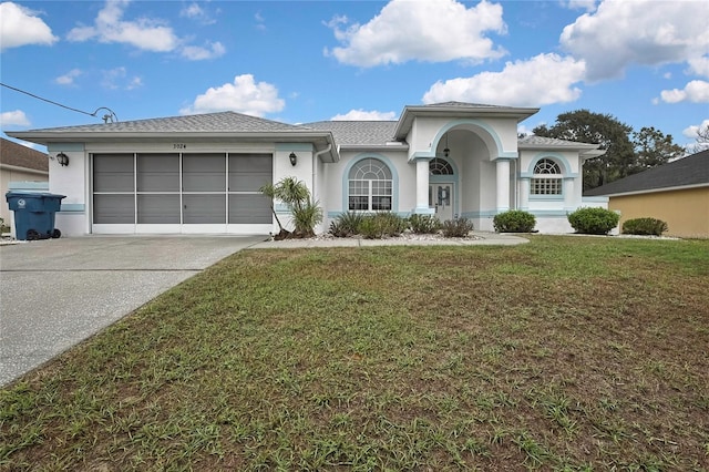 view of front of home with stucco siding, driveway, an attached garage, and a front yard