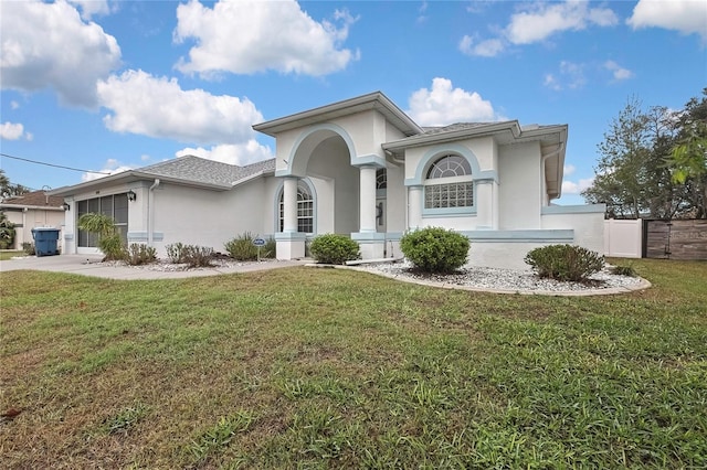 view of front of property featuring stucco siding, driveway, an attached garage, and a front yard