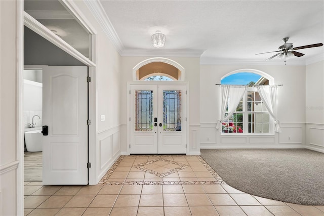 foyer featuring light tile patterned floors, french doors, and ornamental molding