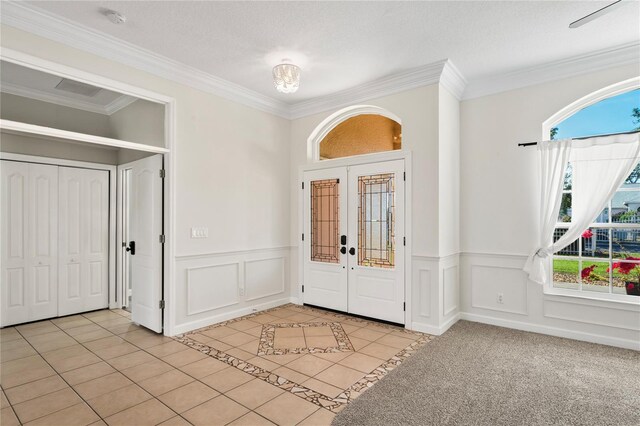 entrance foyer with light tile patterned floors, french doors, and crown molding