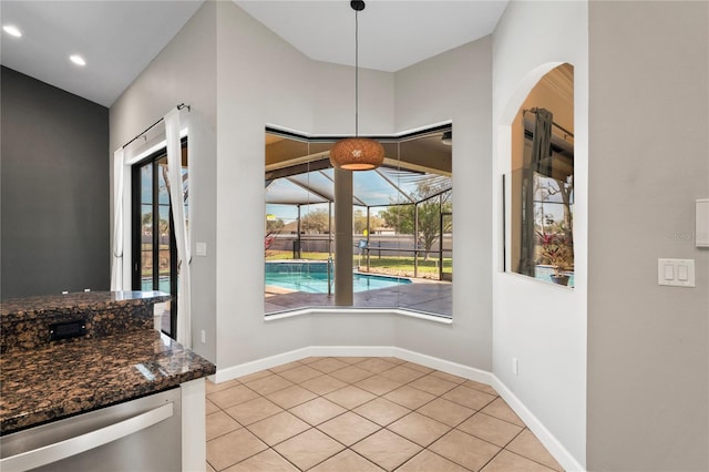 dining room featuring a sunroom, light tile patterned flooring, a wealth of natural light, and baseboards